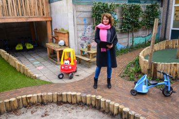 Toezichthouder Judith op de buitenspeelplaats van het kinderdagverblijf waar ze op bezoek is.